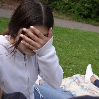 Young Woman Covering Face with Hand Outdoors