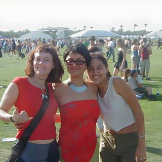 Three Women Posing in a Grass Field