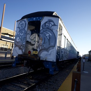 Vintage Train Car with Ornate Blue Artwork at Station