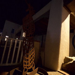 Illuminated Desert Courtyard with Metal Art at Night