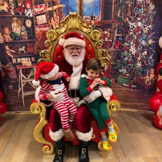 Two Children Visit Santa in His Workshop Grotto