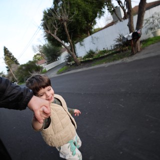 Joyful Child Holding Hand on Suburban Street Walk