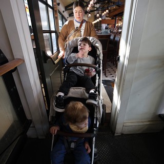 Mother with Two Children Navigating Narrow Restaurant Doorway