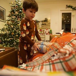 Young Child Opening Christmas Presents on Christmas Morning