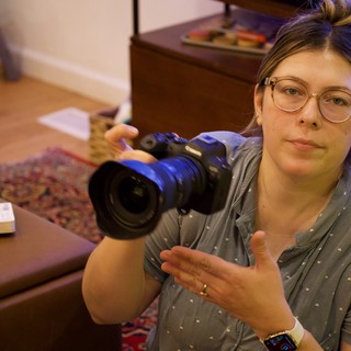 Videographer Showing Camera in Home Studio Setting
