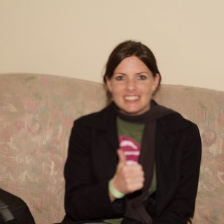 Woman Smiling on Floral Couch Holding Microphone