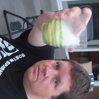 Upside Down Man Holds Green-Striped Drinking Glass