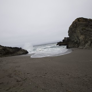 Rugged Cove Where Wild Waves Meet Dark Sand