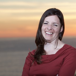 Joyful Woman Laughing at Coastal Sunset