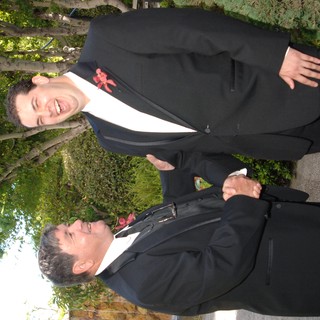 Two Men Sharing a Joyful Handshake at Wedding