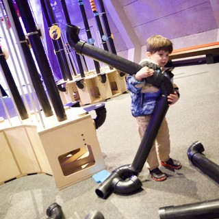Child Playing with Pipes at Interactive Museum Exhibit