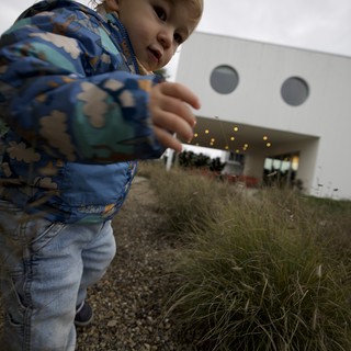 Young Child Playing Giant at Modern Building