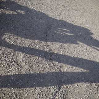 Shadow of a Child on Textured Pavement