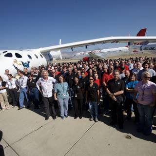 Group of Aviation Enthusiasts Poses in front of White Knight Two Airplanes