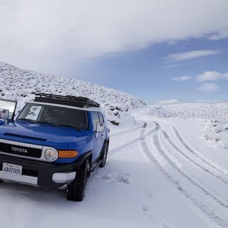 Blue FJ Cruiser Adventure on Snow-Covered Mountain Road