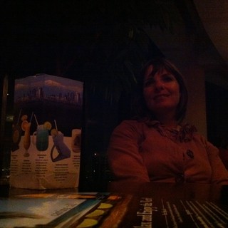 Smiling Woman at Dimly Lit Restaurant Table