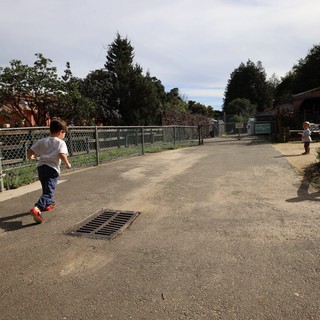 Children Running on Playground Pathway at Dusk