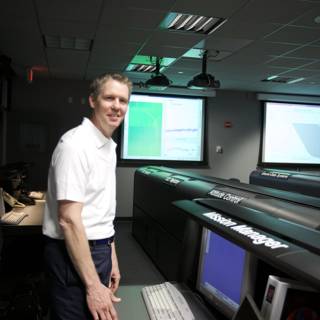 Man Standing in Front of Computer Monitors