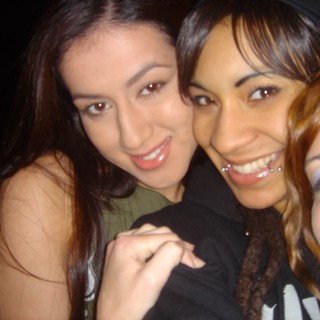 Three Friends Smiling Together at a Nighttime Event