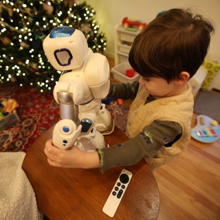 Child Interacting with Humanoid Robot on Christmas Morning