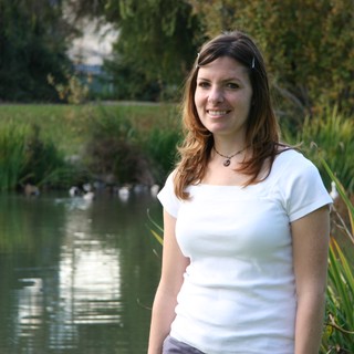 Smiling Woman by a Peaceful Park Pond