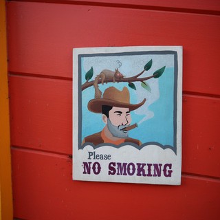 Whimsical No Smoking Sign on Red Wall