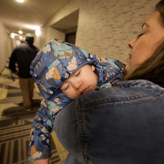 Sleeping Child Carried Through Hotel Hallway at Night
