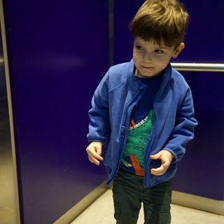Young Boy in Blue Jacket at Science Center