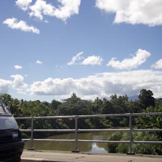 White Van Crossing Bridge with Blue Skies