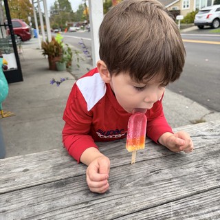 Young Boy Enjoying a Popsicle on a Small Town Street