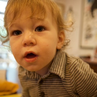Curious Toddler with Blonde Curls at Mealtime
