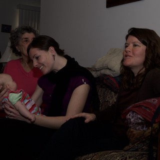 Three Generations Share a Tender Moment with Newborn