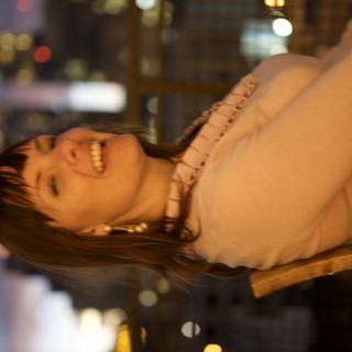 Laughing Woman Against City Skyline at Dusk