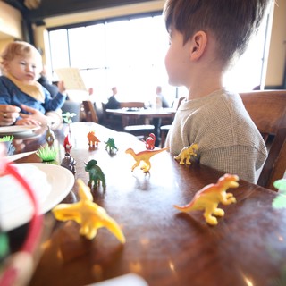 Family Dinosaur Play Time at Restaurant Table