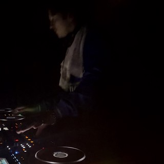 DJ Performing in Dimly Lit Club at Night