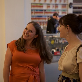 Two Women Sharing a Joyful Conversation at Gallery Event