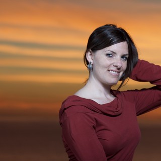 Woman in Red Against a Blazing Sunset Sky