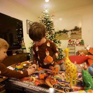 Brothers Opening Christmas Presents Together at Home