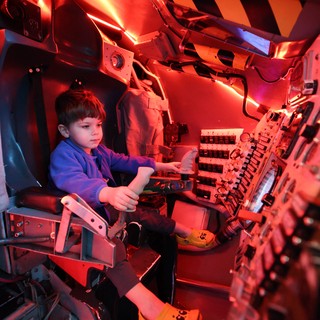 Young Pilot in Illuminated Aircraft Cockpit Simulator