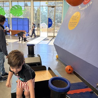 Child Exploring Interactive Science Exhibit at Museum