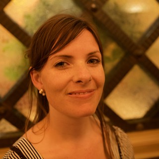 Smiling Woman Framed by Ornate Lattice Window