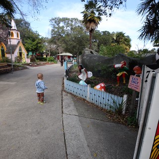 Child Exploring Storybook-Themed Miniature Village at Dusk