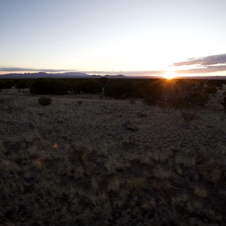 Desert Sunrise Over Distant Mountain Range