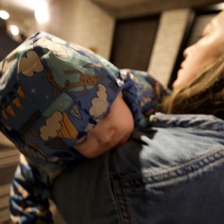 Child in Dinosaur Pajamas Being Carried Indoors