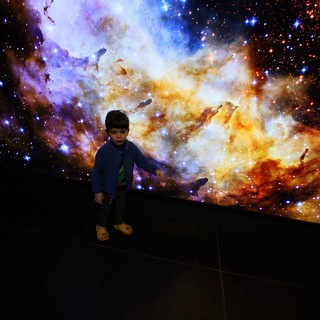 Child Explores Cosmic Nebula at Space Center