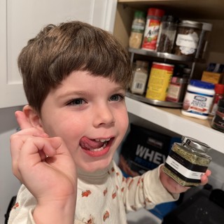 Young Boy Enjoying Spices in Kitchen