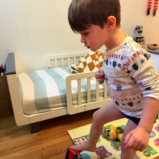 Young Boy Playing in Festive Pajamas on Bedroom Floor
