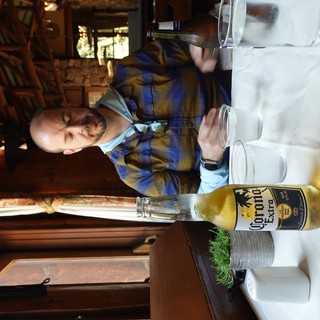 Man Enjoying Corona Beer at Rustic Restaurant