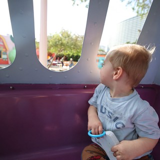 Young Child Gazing Through Playground Windows at Theme Park