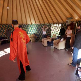 Man in Red Robe Standing in Yurt